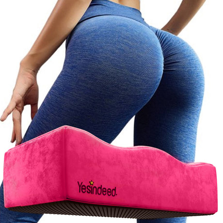 Pink Yesindeed wedge-style BBL pillow pictured in front of a model wearing blue leggings